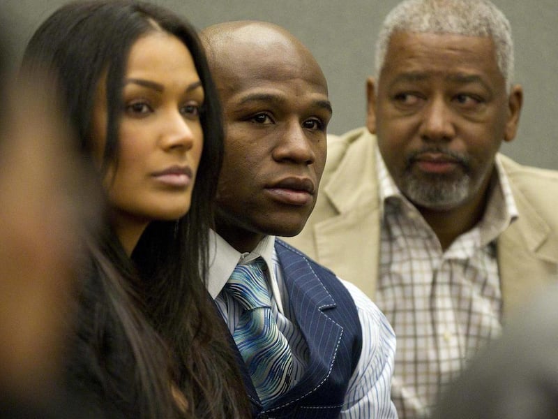 Boxer Floyd Mayweather Jr., center, waits to be called in district court, Monday, Jan. 24, 2011, in Las Vegas. Accompanied by his advisor, Leonard Ellerbe, right, and girlfriend, Shantel Jackson, Mayweather's attorney sought to have his preliminary hearin