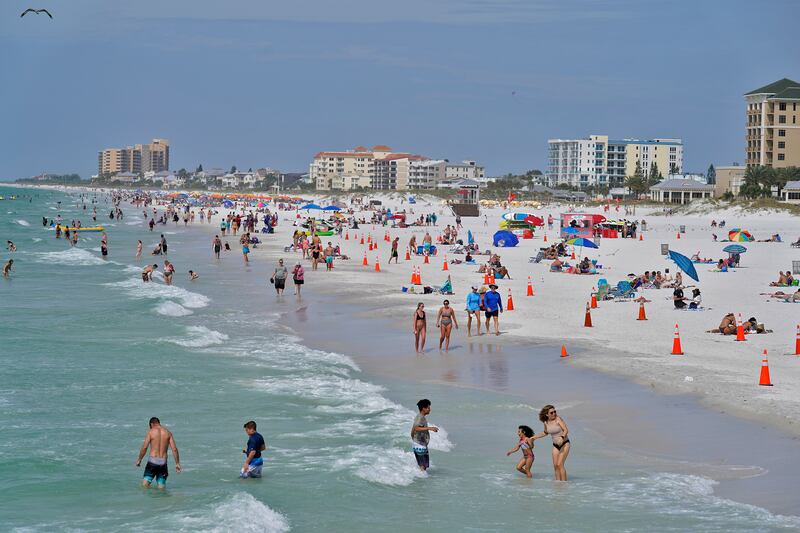 Beachgoers take advantage of the sun, sand, and surf as they spend time on Clearwater Beach Tuesday, March 2, 2021, in Clearwater, Fla., a popular spring break destination, west of Tampa. The coronavirus pandemic’s ending could come after the spring, but it requires work