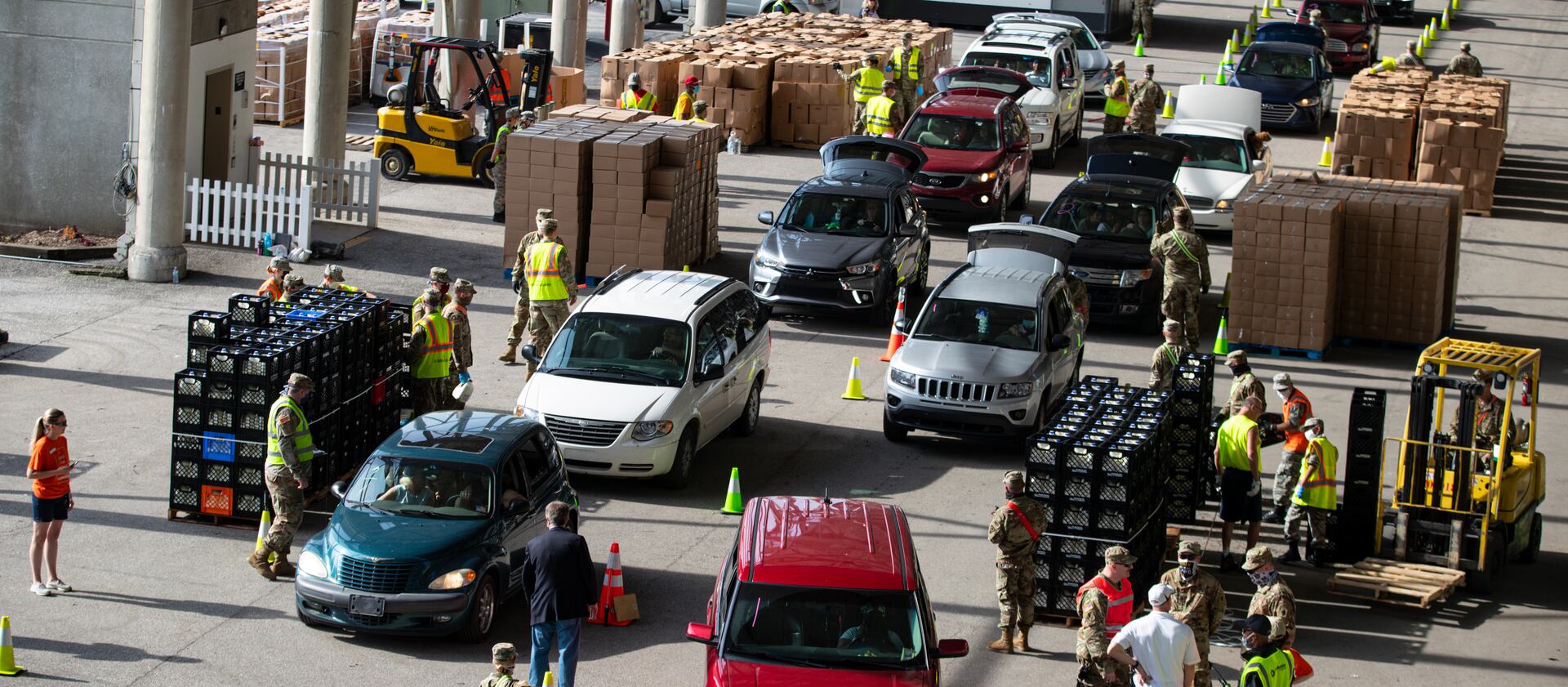 Vehicles move through a food distribution line in Indianapolis. Tough times create concerns over who qualifies for assistance.