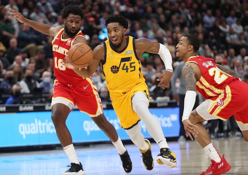 Utah Jazz guard Donovan Mitchell drives on two Hawks defenders