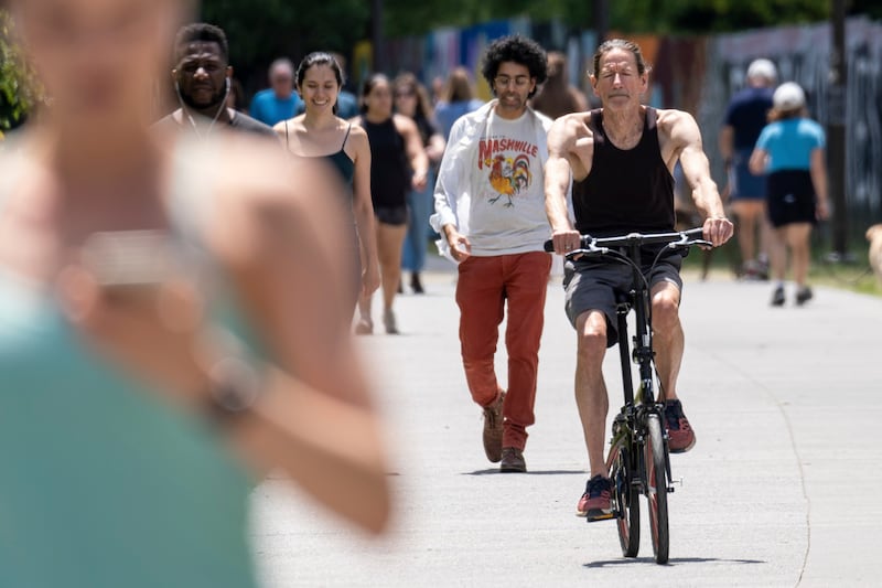 People go maskless on the Atlanta Beltline on after the CDC updated its mask guidelines for COVID-19 vaccinated people.