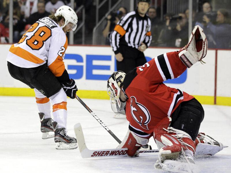 Philadelphia Flyers' Claude Giroux, left, scores on New Jersey Devils goalie Martin Brodeur during the first period of Game 4 of a second-round NHL hockey Stanley Cup playoff series, Sunday, May 6, 2012, in Newark, N.J.