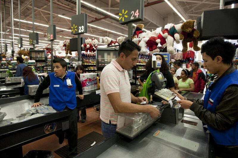 In this Nov. 18, 2011 photo, a man pays at the cash register at a Wal-Mart Superstore in Mexico City. Wal-Mart Stores Inc. hushed up a vast bribery campaign that top executives of its Mexican subsidiary carried out to build stores across Mexico, according