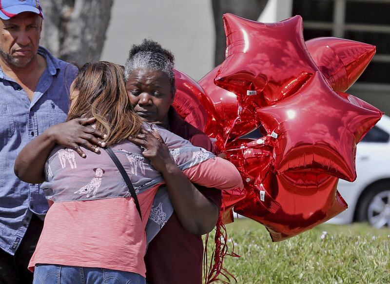 Marjory Stoneman Douglas High School bus driver Pearlie Corker, gets a hug at the school as some teachers return for the first time since the shooting, Friday, Feb. 23, 2018 in Parkland, Fla. Corker arrived at the school as Nicklaus Cruz began to shoot st