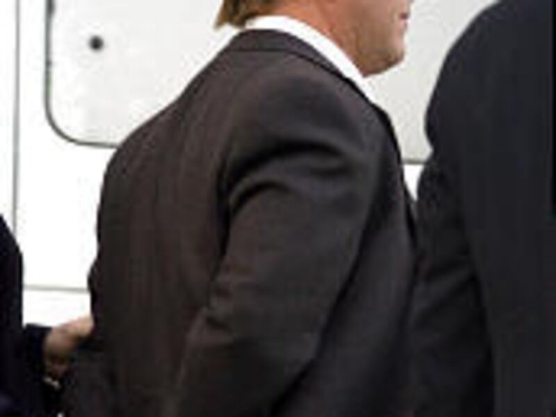 Former Enron CEO Jeffrey Skilling arrives in handcuffs Thursday at federal courthouse in Houston.