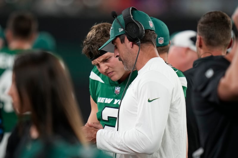 New York Jets quarterbacks Aaron Rodgers, right, and Zach Wilson talk during a preseason game against Tampa Bay.
