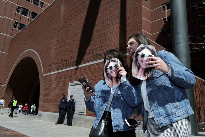 Two people hold cutout photos of actress Lori Loughlin outside federal court in Boston on Wednesday, April 3, 2019, where Loughlin is scheduled to face charges in a nationwide college admissions bribery scandal. (AP Photo/Charles Krupa)