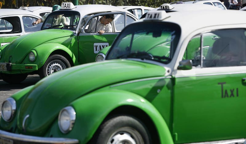 FILE - In this Dec. 28, 2007 file photo, a man steps out of his Volkswagen beetle taxi during an inspection in Mexico City. Mexico City has announced that the last of the iconic Volkswagen Beetle taxis will be withdrawn from service by the end of 2012.