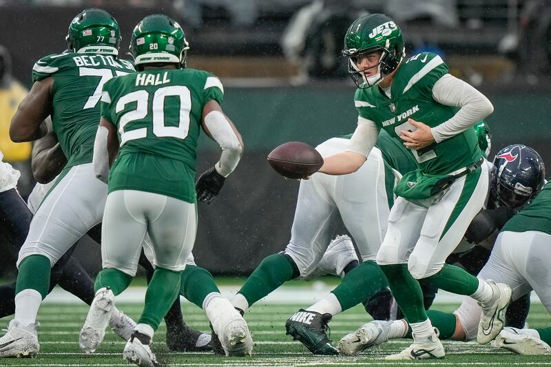 New York Jets quarterback Zach Wilson hands the ball off to running back Breece Hall during a game on Sunday, Dec. 10, 2023.