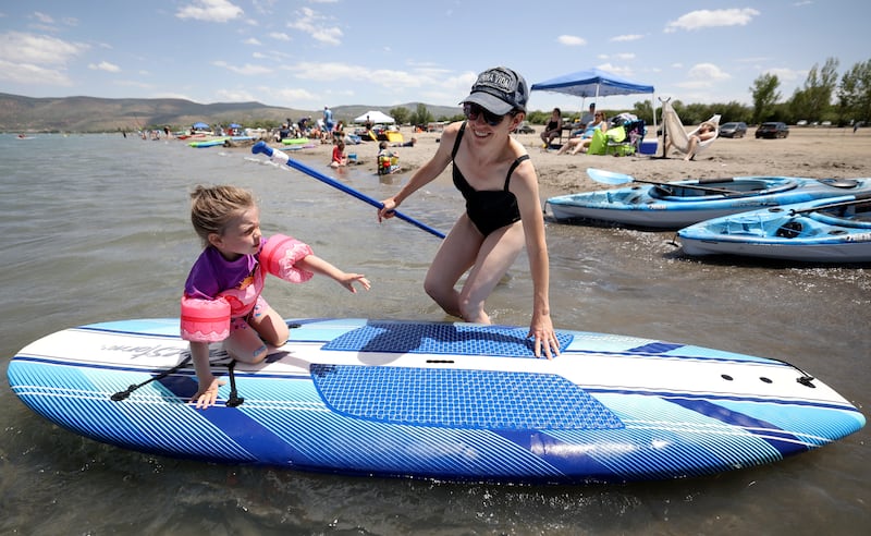 Christine Ray pushes daughter Bonnie Ray on a paddle board at Bear Lake’s Rendezvous Beach in Rich County.