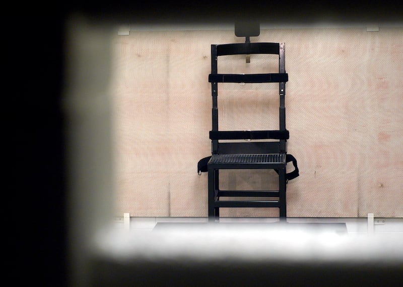 A firing squad chair in the execution chamber at Utah State Prison as seen through the rifle port May 5, 2004.