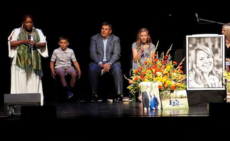Cathryn McGill, standing, performs a song at a memorial service for Michael Riordan's wife Jennifer, who died on Tuesday in the Southwest Airlines flight 1380 accident, at Popejoy Hall on the campus of the University of New Mexico in Albuquerque, N.M., Su
