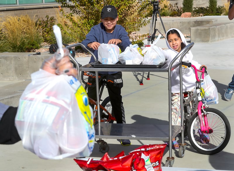 Jerson Arroyocruz and his sister Genesis get grab-and-go lunches for their family at Edison Elementary School. Expanded child nutrition help is part of the $3.5 trillion budget proposal Democrats hope to get through reconciliation,