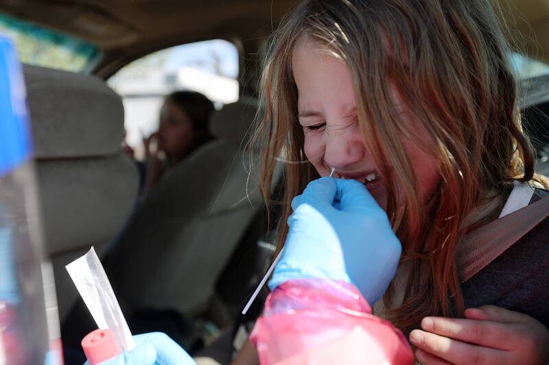 Katelynn Gajarski reacts as she receives a COVID-19 test at a NOMI Health site in West Valley City on Monday, May 16, 2022.
