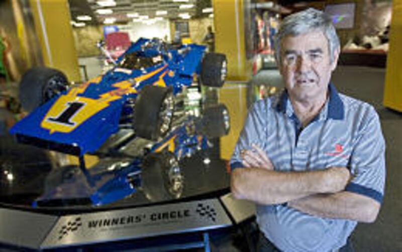 Al Unser, Sr. stands next to the Johnny Lightning Special, the car he drove to victory in the 1971 Indy 500