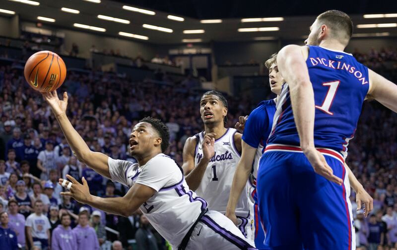 Kansas State’s Tylor Perry, left, throws up a reverse layup that helps the team defeat rival Kansas 75-70 in overtime.