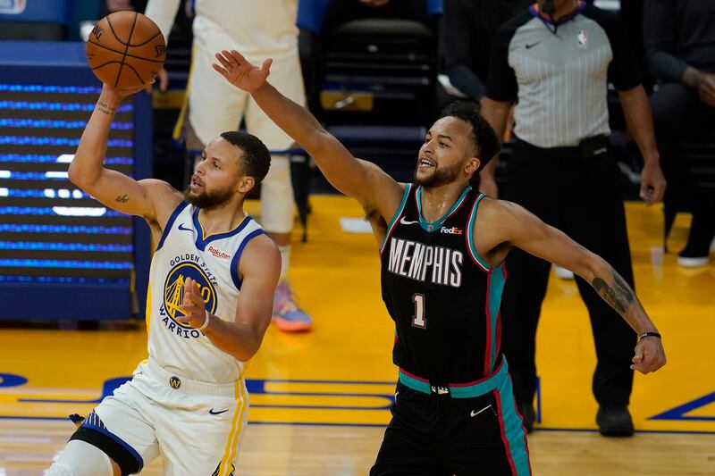 Golden State Warriors guard Stephen Curry, left, shoots against Memphis Grizzlies forward Kyle Anderson on May 16, 2021.