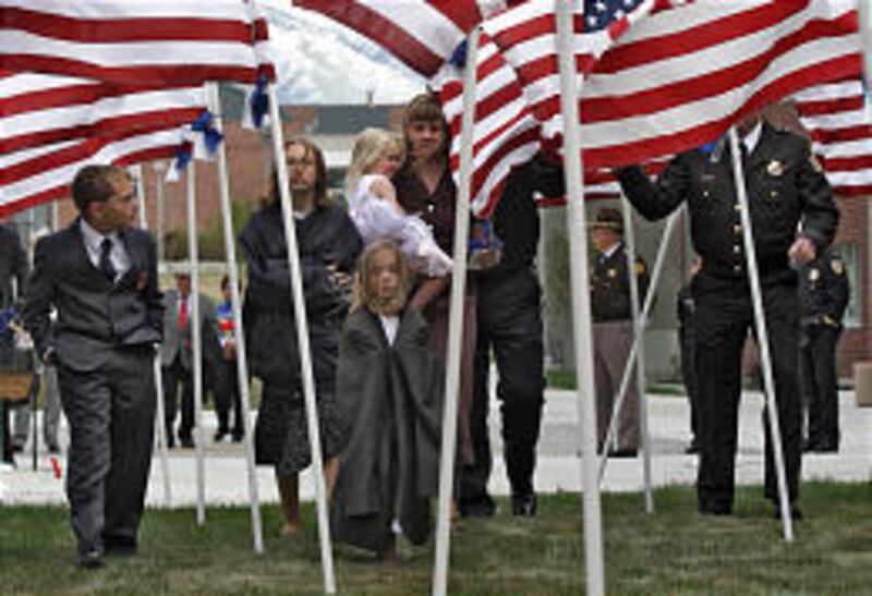 Holley Orr walks with children Tyler, left, Jessica, Kaylee and Ashlee to place a marker honoring her husband, Kevin Orr, during the Fallen Officers Memorial Service at Salt Lake Community College's Miller Campus in Sandy on Thursday. Orr was killed in a