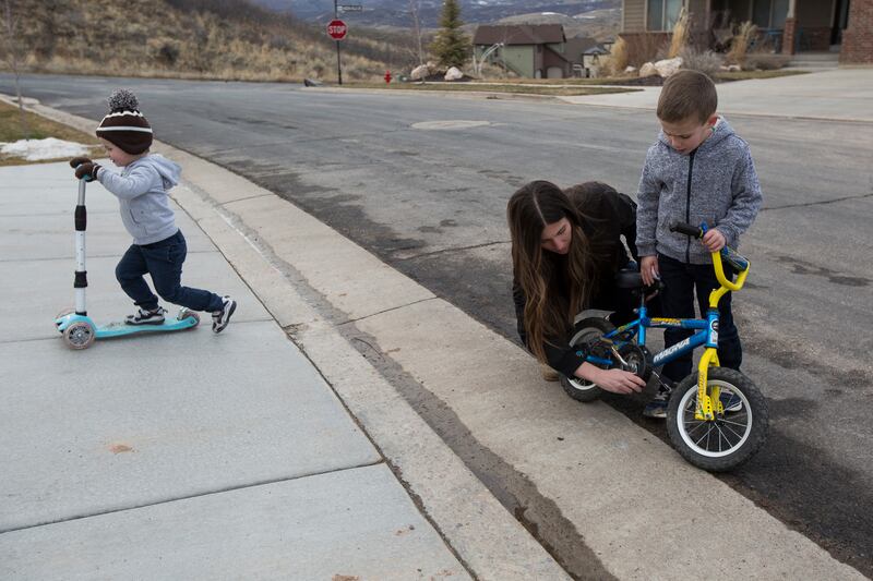 Stephanie Krauss of Mountain Green assists her son, Finn, 5, with a bike chain as one of her other sons, Wyatt, 3, rides his scooter at the Krauss' home in Mountain Green on Monday, Feb. 5, 2018. Stephanie is a signee of the Wait Until 8th pledge in which
