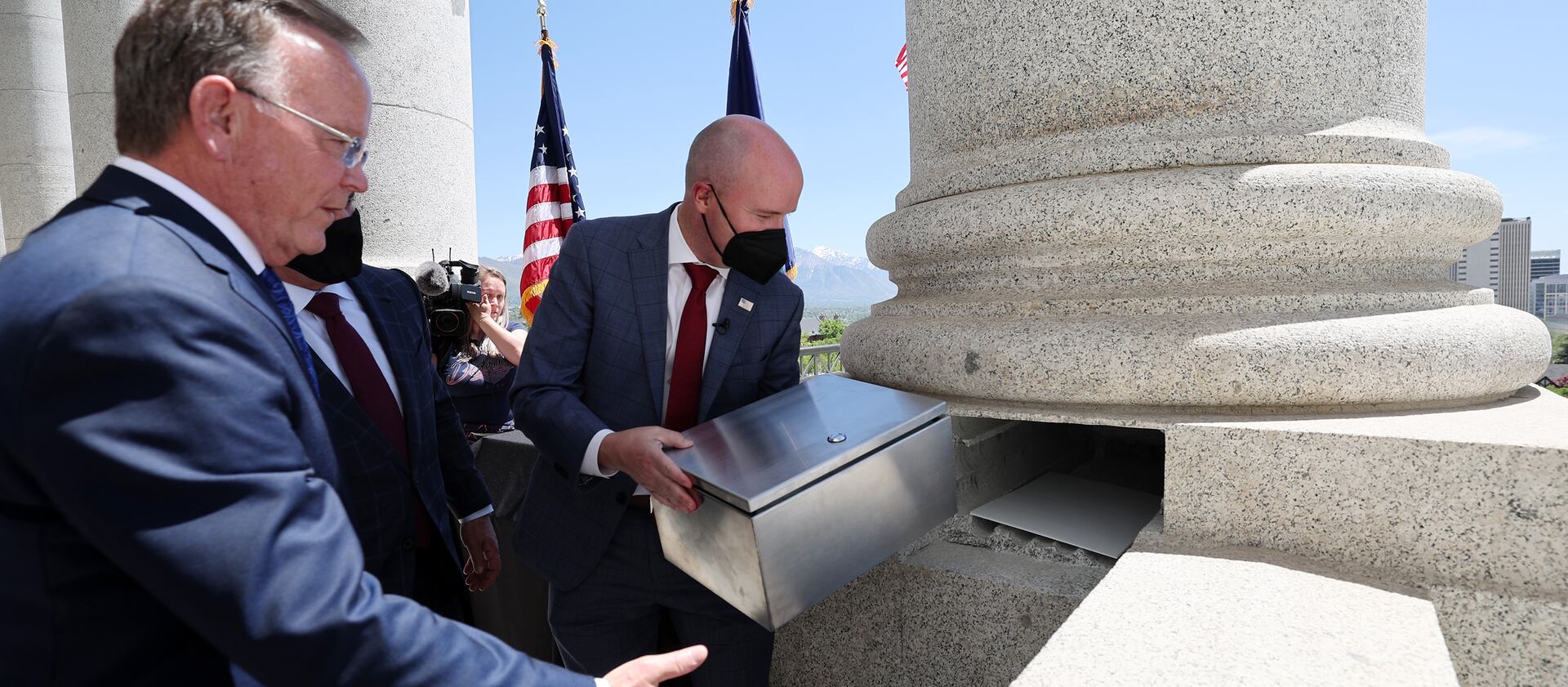 Gov. Spencer Cox places a time capsule into one of the columns at the Capitol in Salt Lake City.