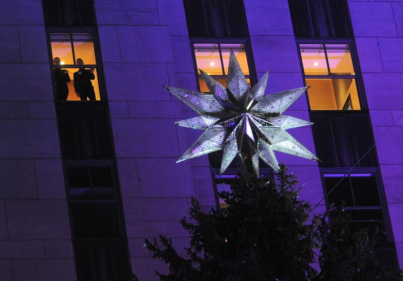 People at the star of the Rockefeller Center Christmas tree as it is lit during the 83rd Annual Rockefeller Center Christmas Tree Lighting Ceremony on Wednesday, Dec. 2, 2015, in New York. The Norway Spruce tree stands at about 78 feet tall and is lit wi