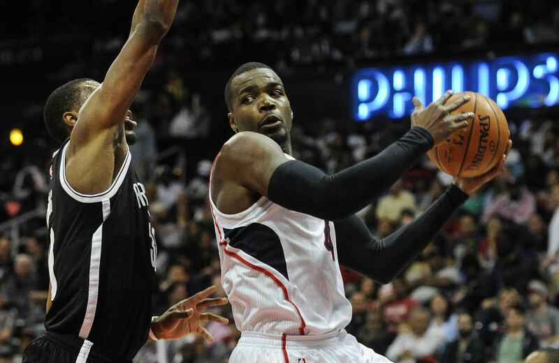 Atlanta Hawks forward Paul Millsap, right, looks to pass as Brooklyn Nets forward Thaddeus Young (30) defends during the first half of an NBA basketball game, Saturday, April 4, 2015, in Atlanta.