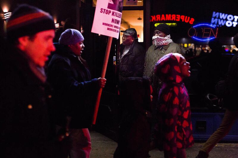 Bystanders look on as demonstrators march from a memorial for Kimani "Kiki" Gray on Thursday, March 14, 2013 in the East Flatbush neighborhood of Brooklyn, N.Y. The 16-year-old was shot to death on a Brooklyn street last Saturday night by plainclothes pol
