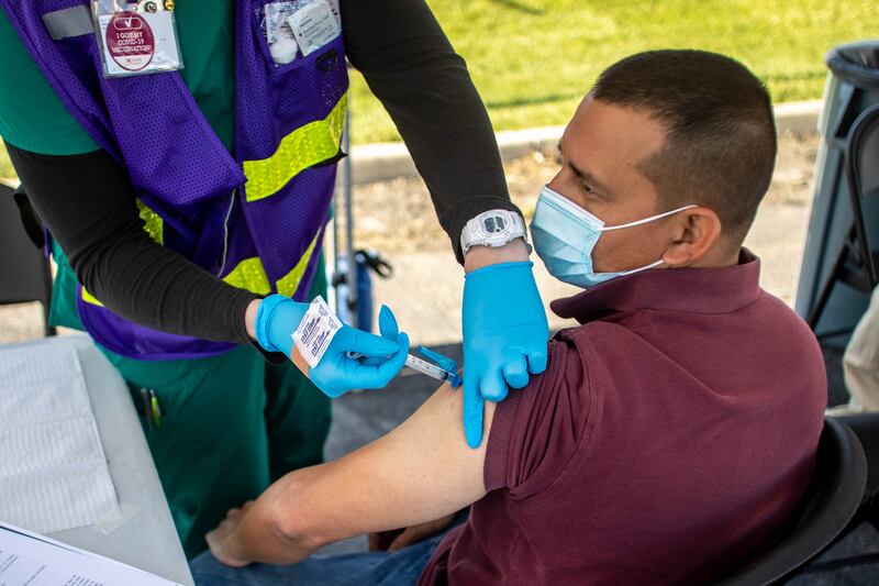 A health care worker gives Carlos Ramirez a COVID-19 vaccine at a pop-up vaccination event in Utah.