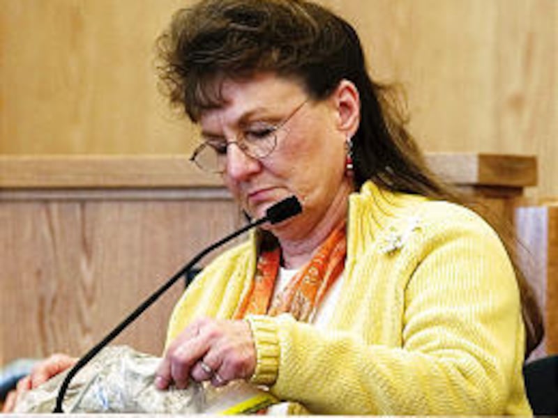 JoAnn Autry looks at a shoe that belonged to her daughter, Trisha Ann, during Cody Lynn Nielsen's murder trial Wednesday in Logan.