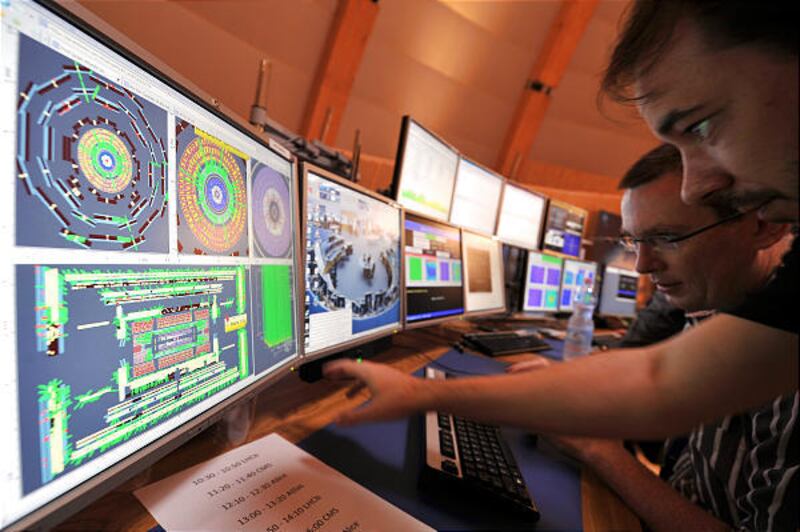Scientists at CERN study computer screens Wednesday as the Large Hadron Collider fires particle beams near the speed of light.