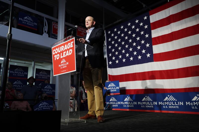 Evan McMullin stands at a podium in front of a large American flag and speaks to supporters in Salt Lake City.