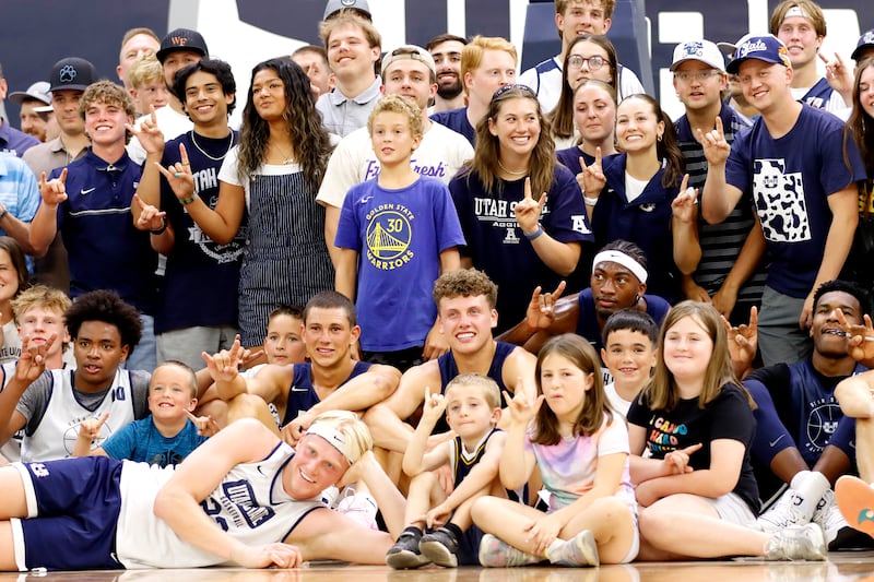 Utah State basketball players pose for a photograph with Aggie fans following their open practice Monday night at the Wayne Estes Center in Logan.