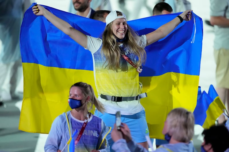 A Ukrainian athlete reacts as she comes into the stadium during the opening ceremony at the 2020 Summer Olympics in Tokyo.