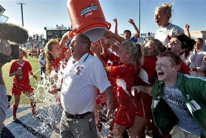 Alta coach Lee Mitchell gets dowsed by his team after Hawks beat Brighton 2-0 to claim their third 5A soccer championship in a row.