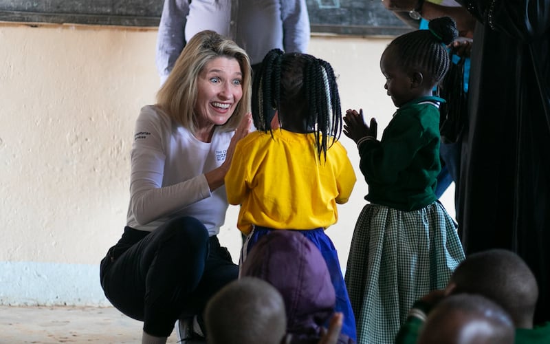 Relief Society General President Camille N. Johnson visits with two girls in a remote area of Uganda in March 2023.