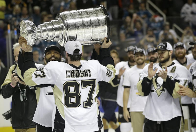 Pittsburgh Penguins center Sidney Crosby (87) hands the Stanley Cup to defenseman Trevor Daley after Game 6 of the NHL hockey Stanley Cup Finals against the San Jose Sharks in San Jose, Calif., Sunday, June 12, 2016. The Penguins won 3-1 to win the series