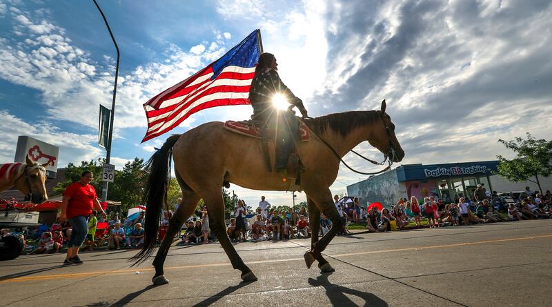 Elena Limon from the Cross E Ranch carries the American Flag during the 65th annual Grand Parade along Main Street in Bountiful on Friday, July 20, 2018.
