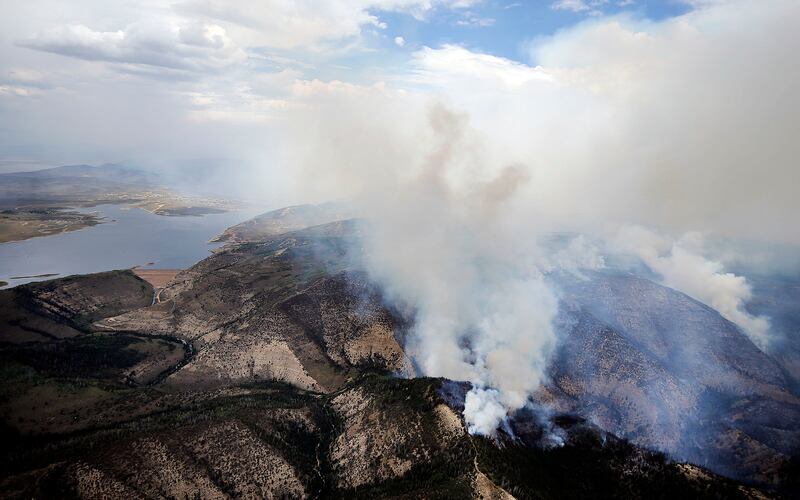 FILE- In this July 5, 2018, file photo, smoke rises from a wildfire near Strawberry Reservoir in Utah. This year is projected to be among Utah's worst in terms of land burned. Estimates show more than $47 million have been spent on Utah's wildfires so far