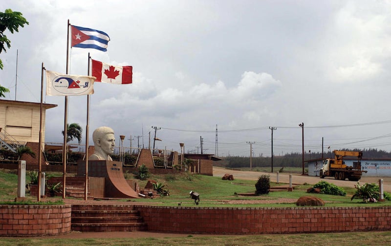 In this June 22, 2011 photo, a Canadian flag flies alongside the Cuban flag at the entrance of Pedro Sotto Alba nickel processing plant in Moa, Holguin province, Cuba. A Cuban court has convicted a dozen people of corruption, including high-ranking gover