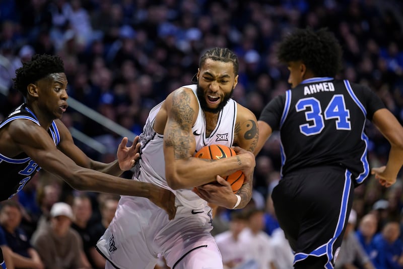 UCF forward Jordan Burks, center, steals the ball away from BYU forward AJ Dybantsa, left, during game, Tuesday, Feb. 24, 2026, in Provo, Utah.