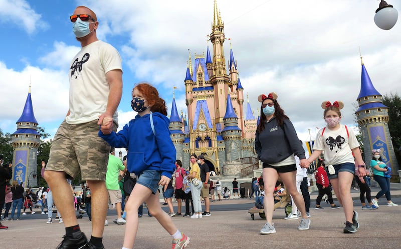 A family walks past Cinderella Castle in the Magic Kingdom at Walt Disney World.