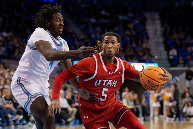 Utah guard Deivon Smith (5) drives against UCLA guard Will McClendon (4) during the first half of an NCAA college basketball game, Sunday, Feb. 18, 2024, in Los Angeles.