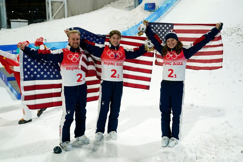 Gold medal winners Ashley Caldwell, Christopher Lillis and Justin Schoenefeld celebrate with the American flag.