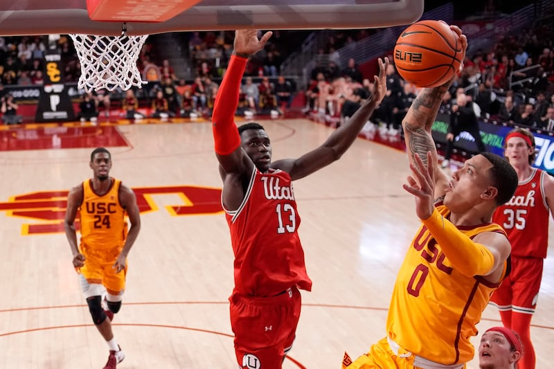 Southern California guard Kobe Johnson (0) shoots as Utah center Keba Keita (13) defends during the second half of an NCAA college basketball game Thursday, Feb. 15, 2024, in Los Angeles.
