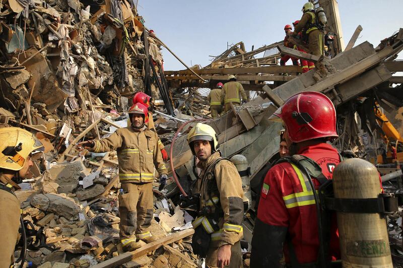 Iranian firefighters work at the scene of the collapsed Plasco building after being engulfed by a fire, in central Tehran, Iran, Thursday, Jan. 19, 2017. Iran's state-run Press TV says dozens of firefighters have been killed in the collapse of a burning h