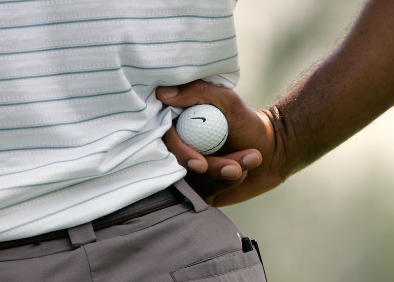 Tiger Woods holds a Nike golf ball.