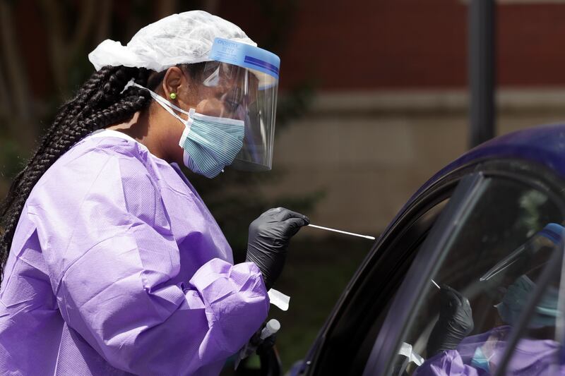 In this July 2, 2020, file photo, Liza Collins, a travel nurse from Ville Platte, La., administers a COVID-19 test at the Rutherford County Health Department, in Murfreesboro, Tenn.