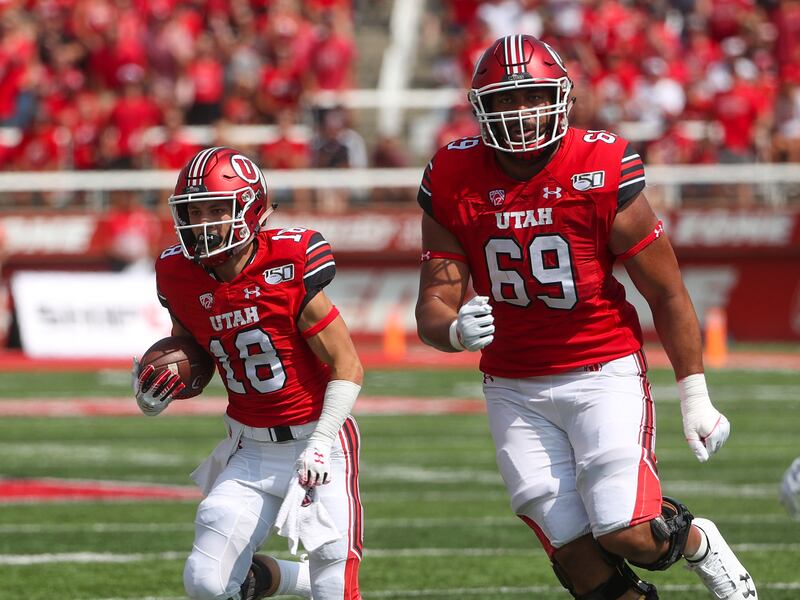 Utah Utes wide receiver Britain Covey (wearing red) follows the lead of Utah Utes offensive lineman Simi Moala.