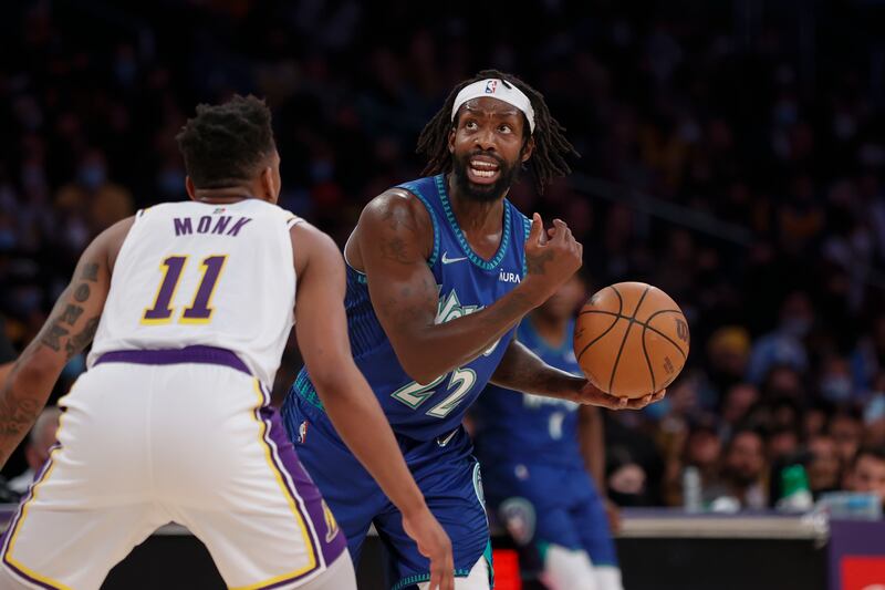 Minnesota Timberwolves guard Patrick Beverley is defended by Los Angeles Lakers guard Malik Monk during an NBA basketball game.