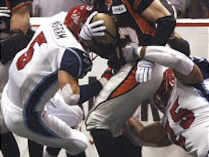 Los Angeles Avengers Kevin Ingram, left, and Ionnie Ford tackle Utah Blaze receiver Tom Pace during Saturday's game.